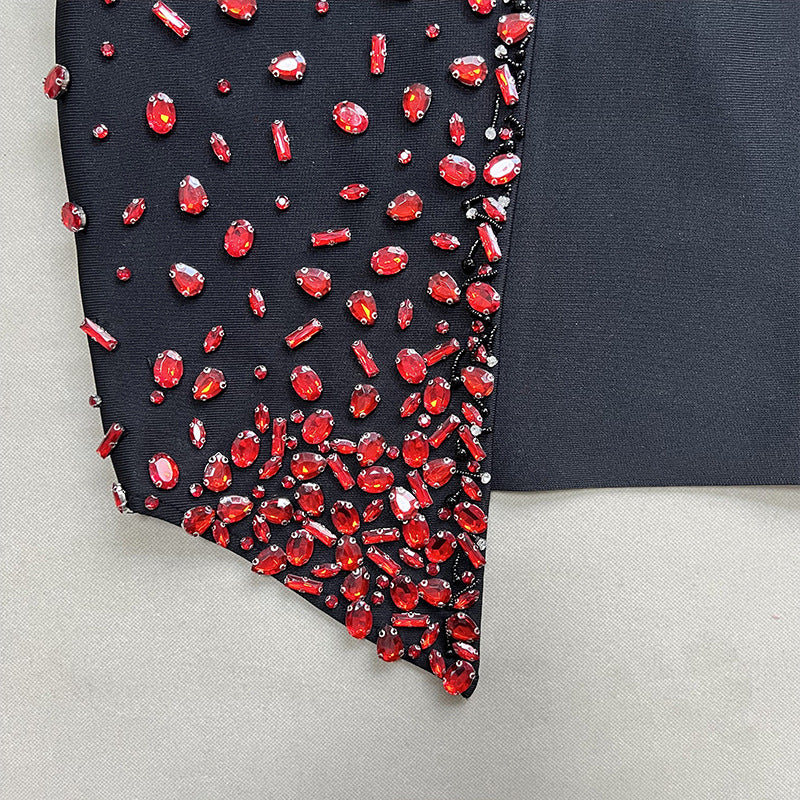 Black dress with red gemstones on a gray background