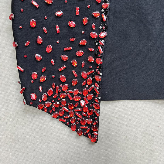 Black dress with red gemstones on a gray background